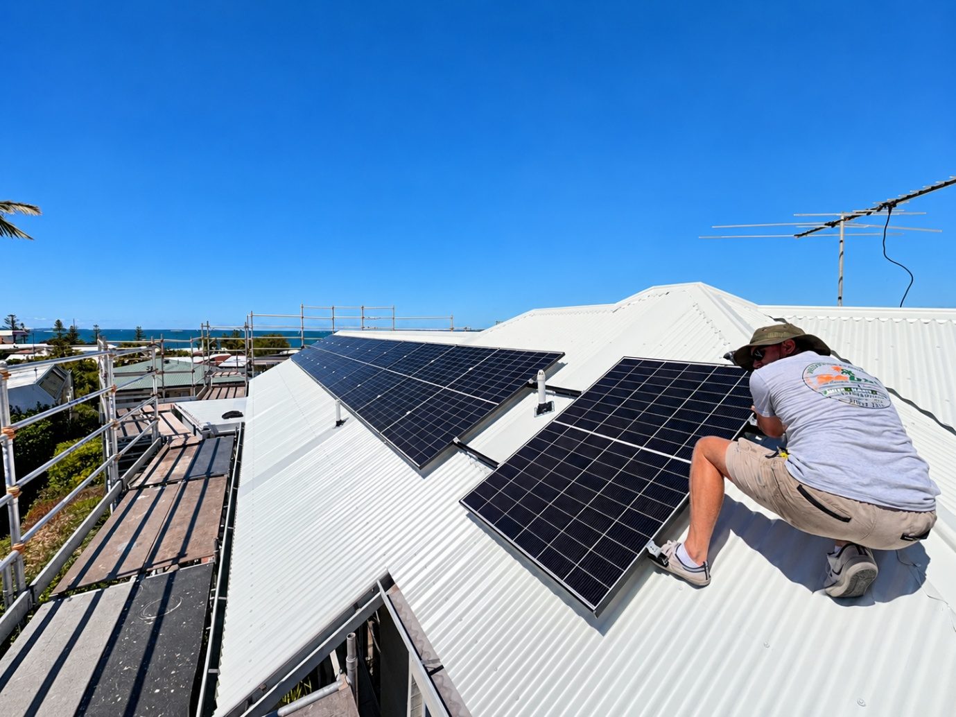 SEBSS installer fitting new solar panels on a white Colorbond roof in Manly QLD after hail damage